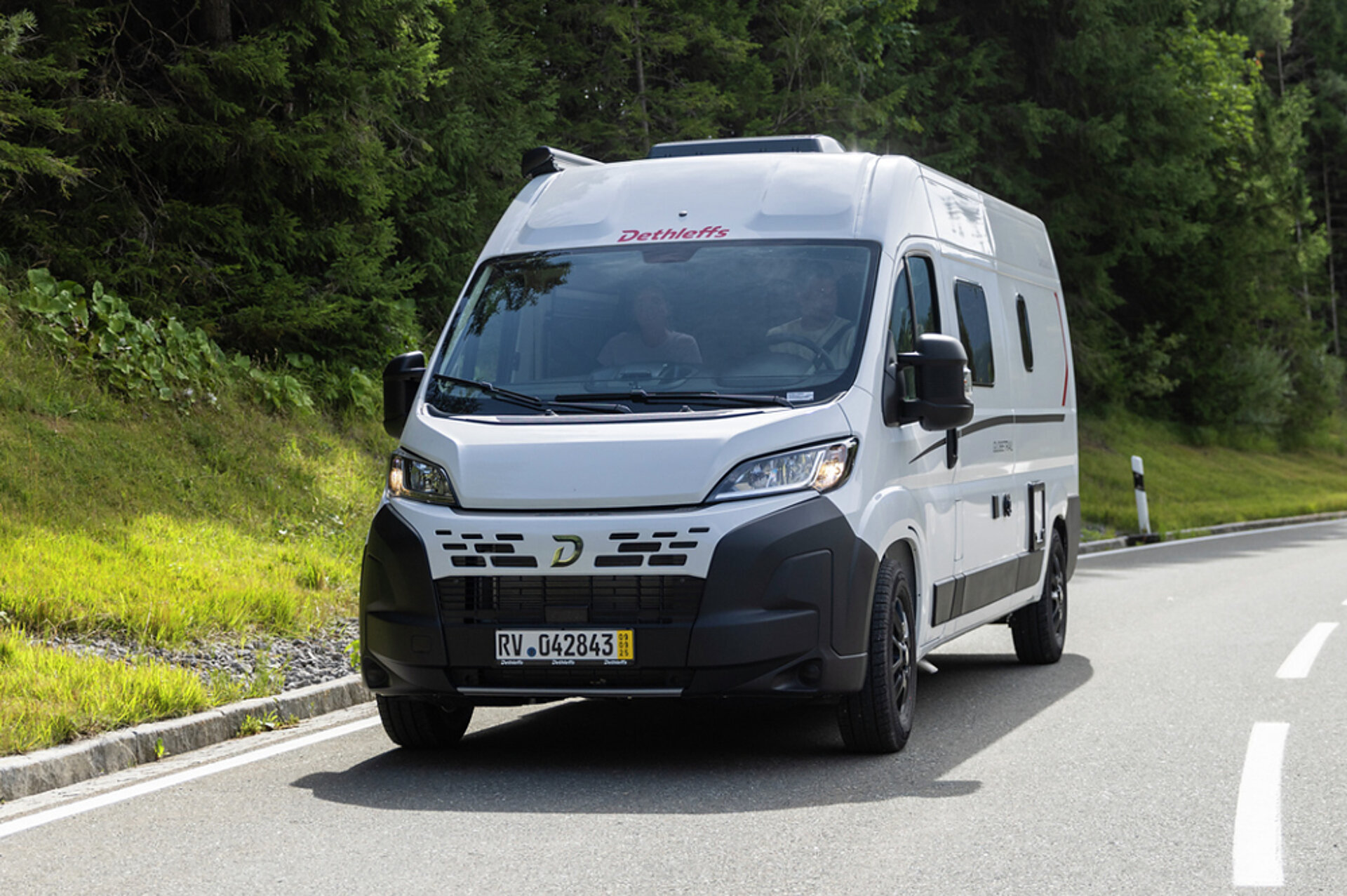 Weißer Kastenwagen auf einer Straße.
